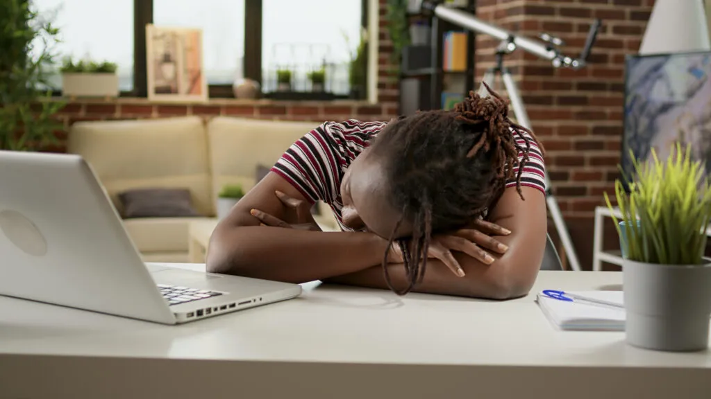 tired overworked woman falling asleep desk with laptop working pressure remotely from home unhappy exhausted employee relaxing after overload work feeling sleepy
